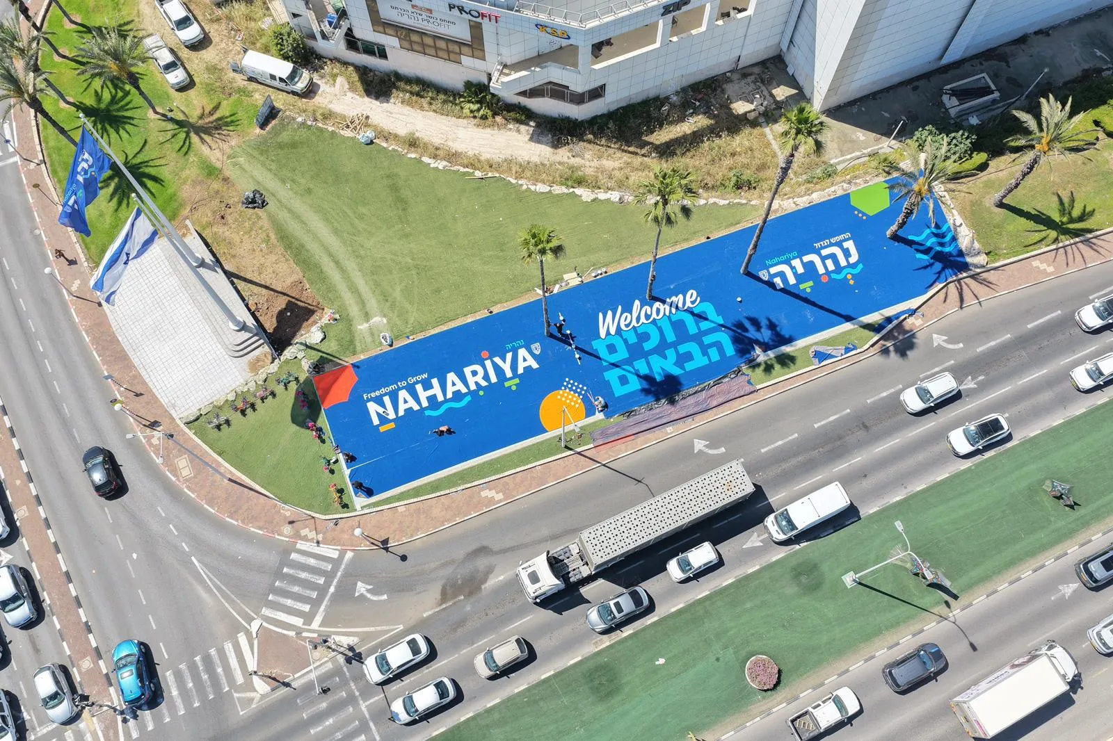 Aerial view of a giant ColorPlay turf welcome sign beside a road