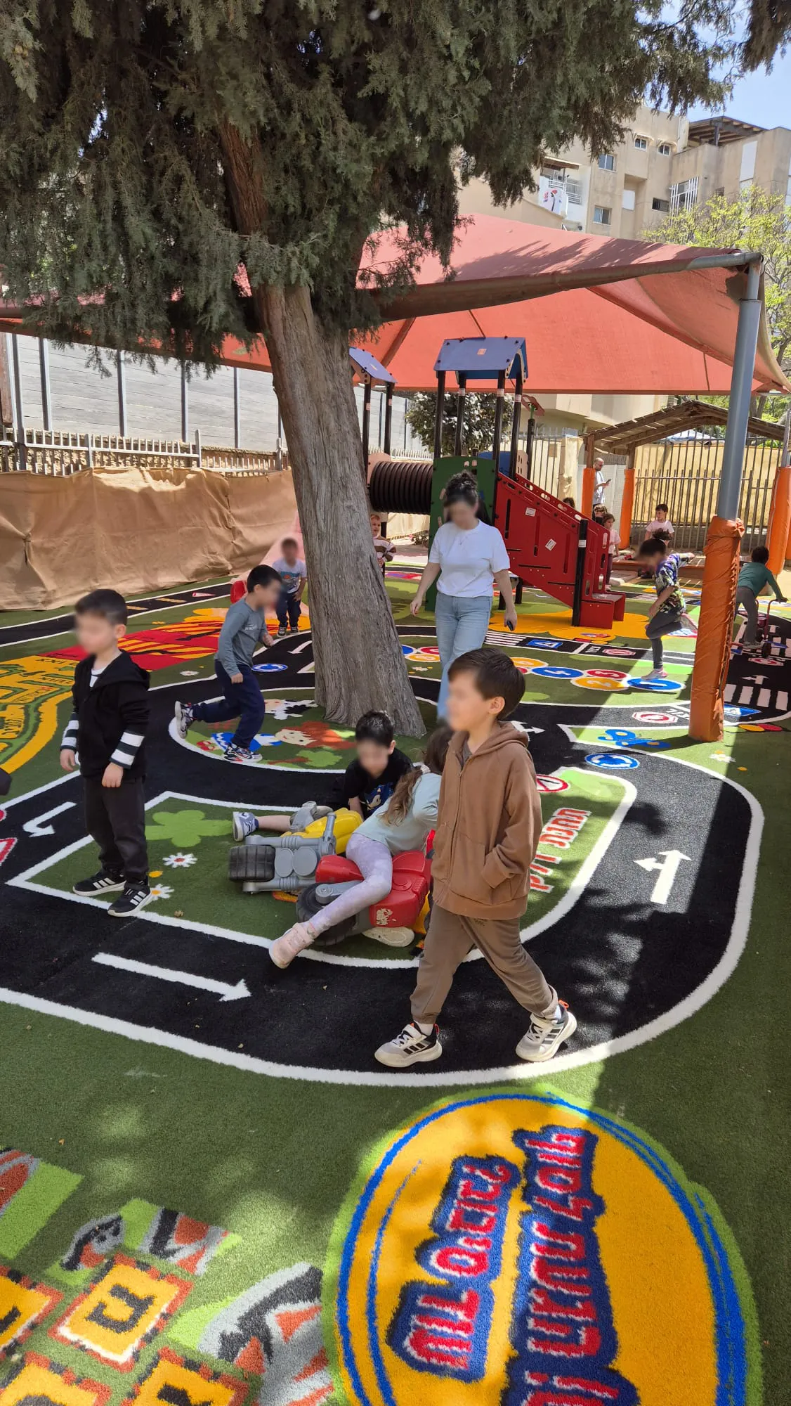 Children playing on a colourful road-track turf surface