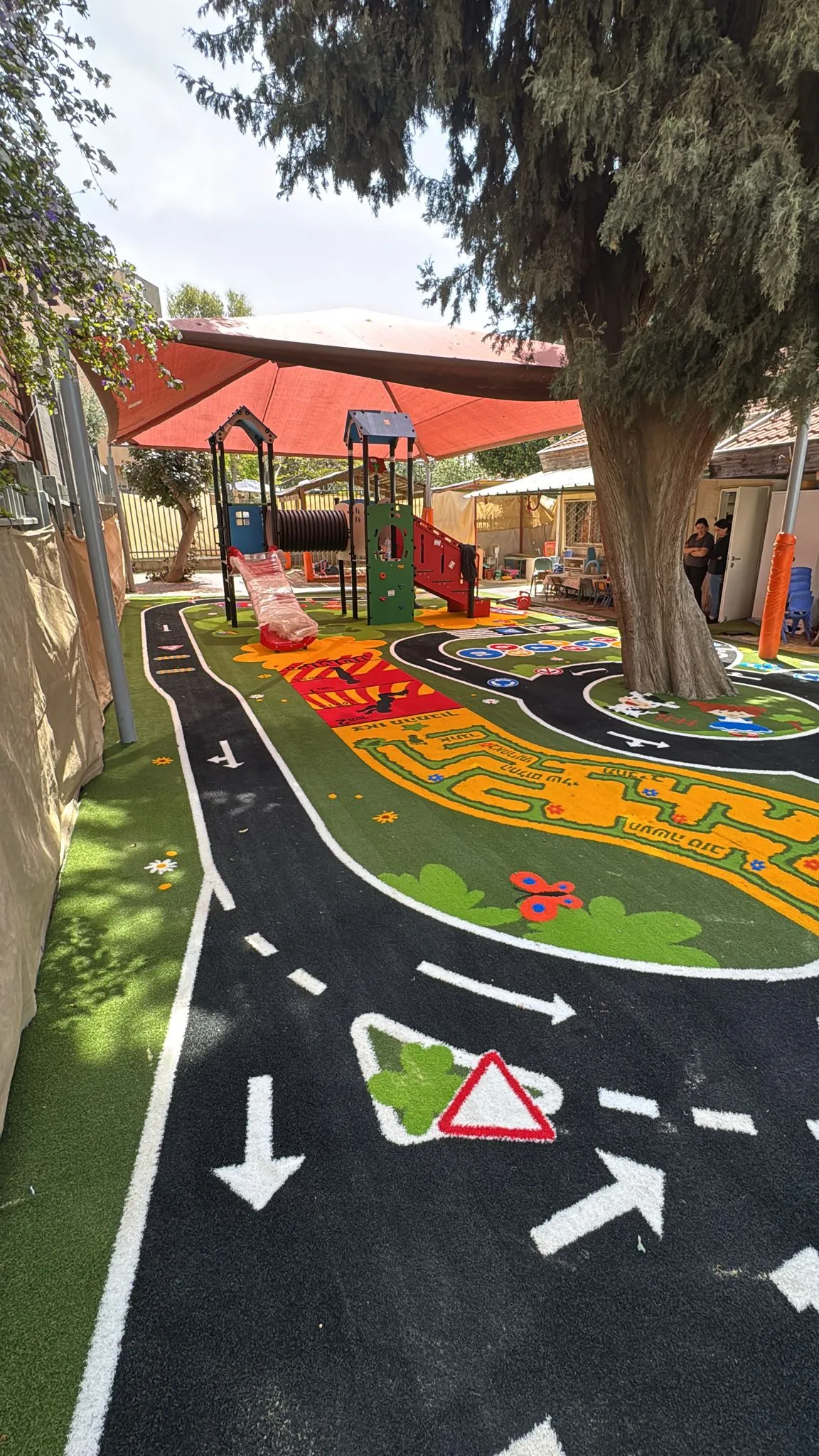 Winding road-and-racetrack play surface through a courtyard