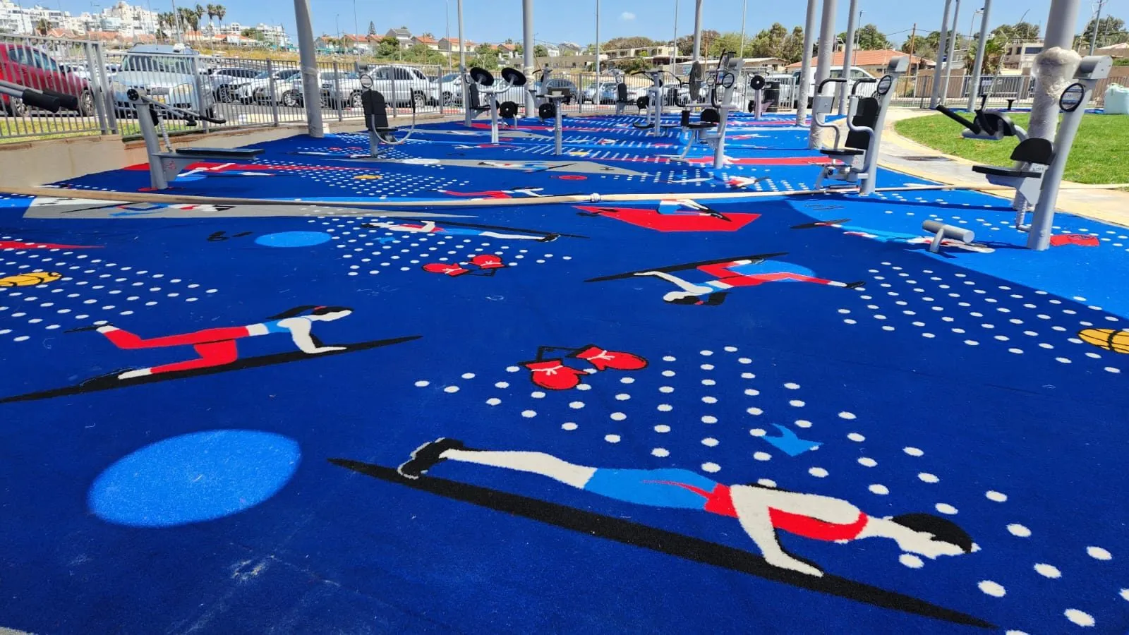 Close view of red, white and black exercise figures — planks, boxing and stretches — tufted into the deep-blue artificial-grass surface