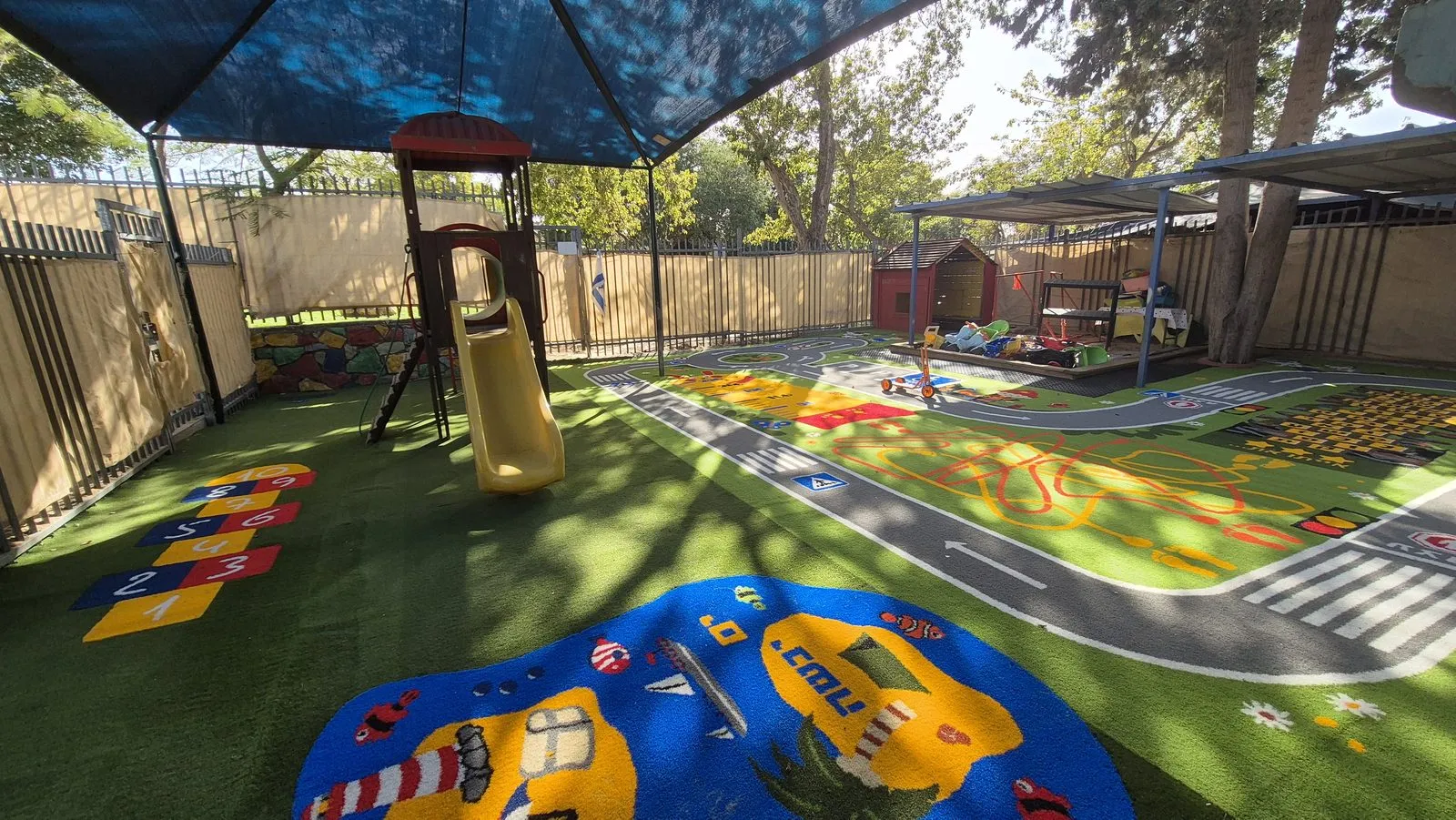 The finished play surface with a looping grey road circuit, crossings and signs, a numbered hopscotch grid and a blue underwater island with a submarine