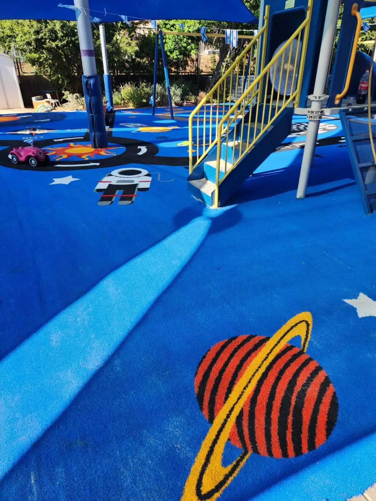 Space-themed play surface with planets, an astronaut and stars