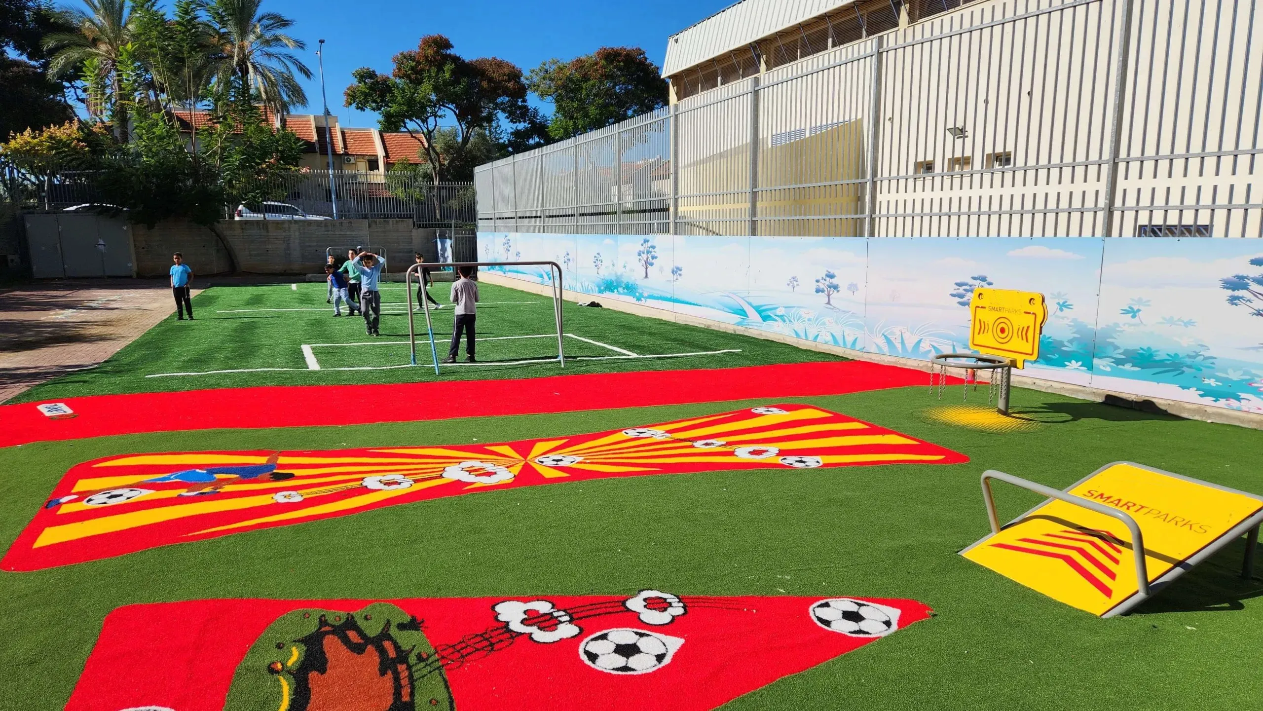 Football pitch in artificial grass with a goal and children playing